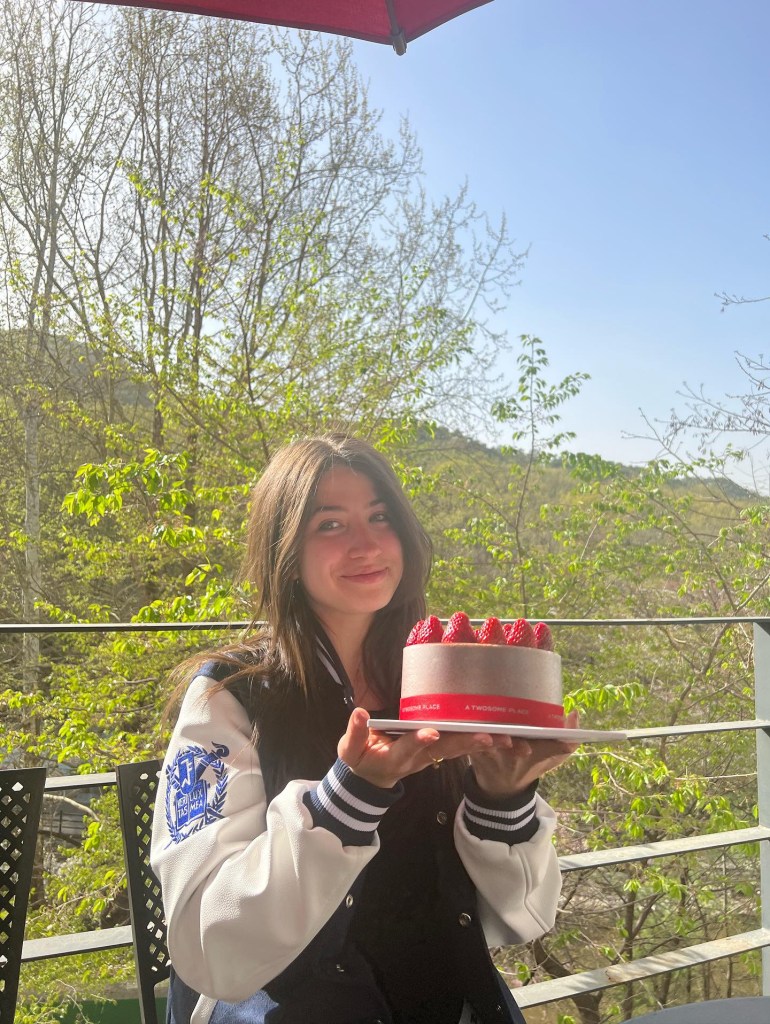 Natasha holding a birthday cake from 'A Twosome Place'